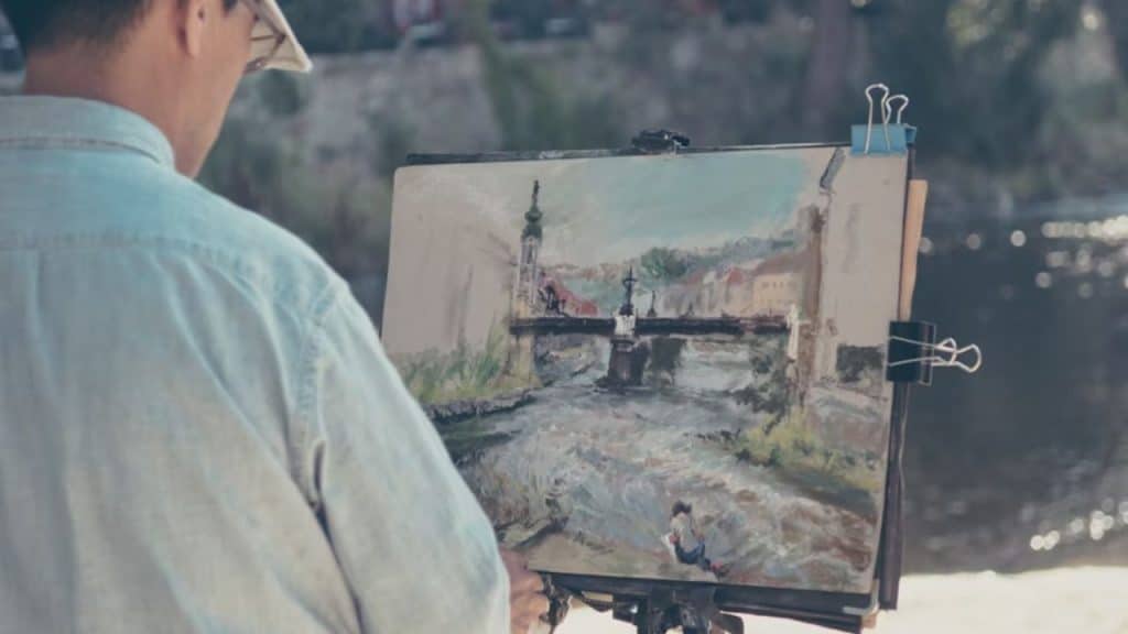 Man painting or working on a hobby in a home studio