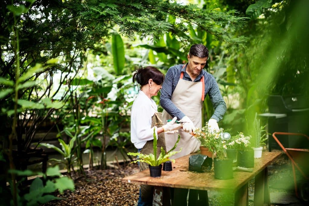 The man is helping the woman plant flowers.