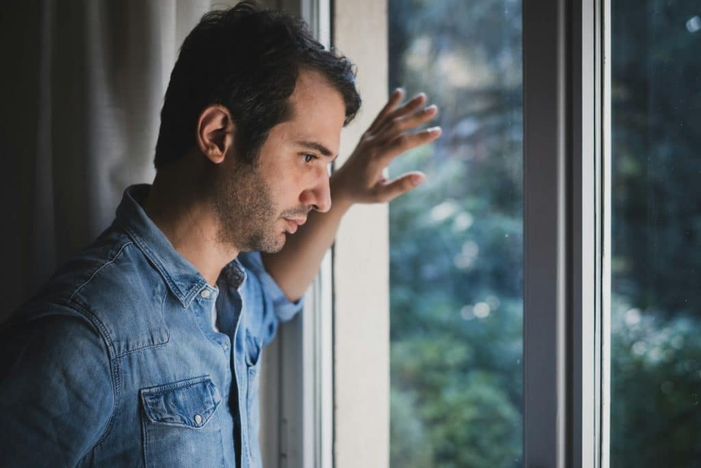 The sad man is looking out the window.
