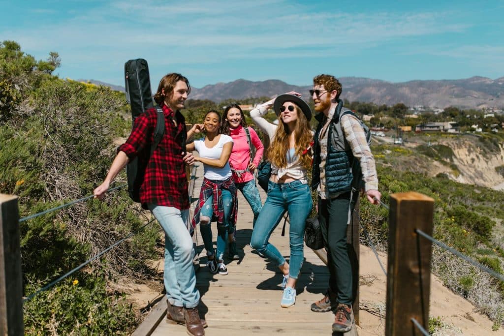 The group of friends are hanging out on a hiking trail.