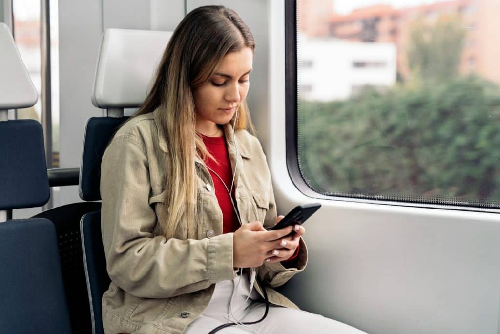 The woman is using her phone on public transportation.