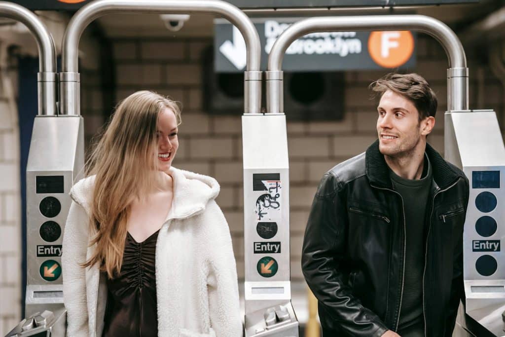 The couple is walking through a turnstile.