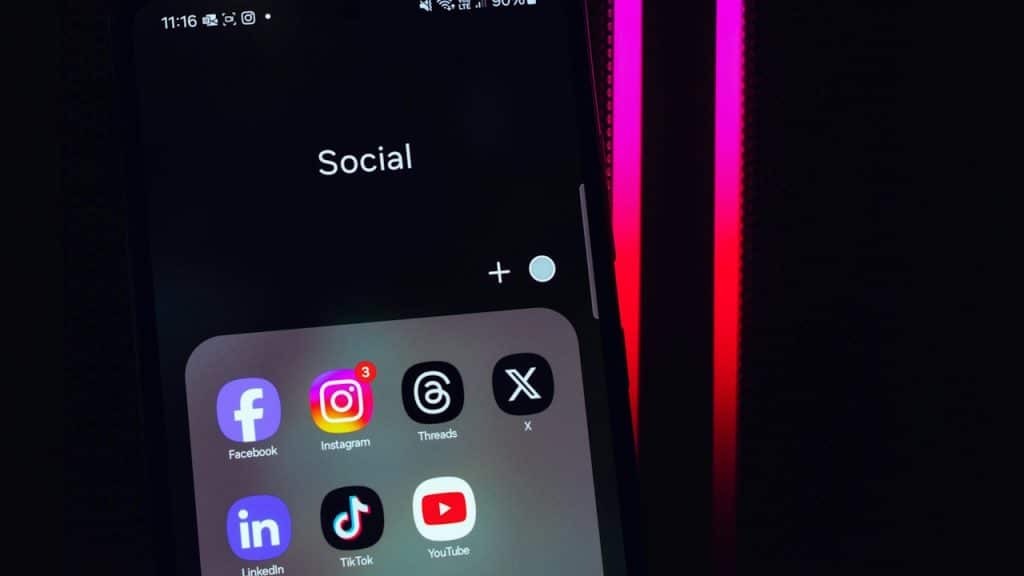 A close-up of a smartphone screen displaying a folder labeled "Social" containing app icons.