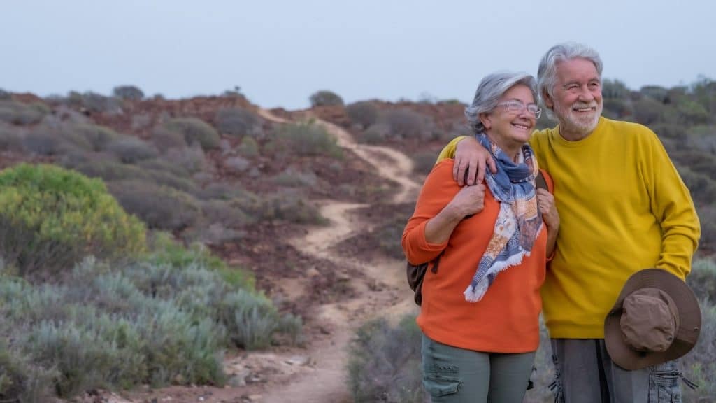 An older couple trekking together.