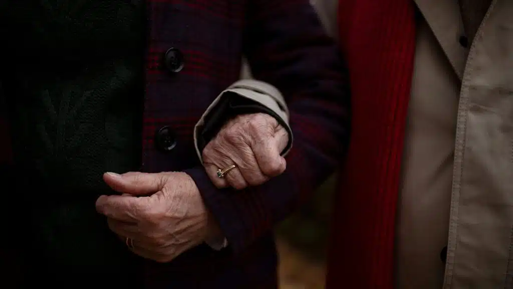 An older couple standing with arms intertwined.