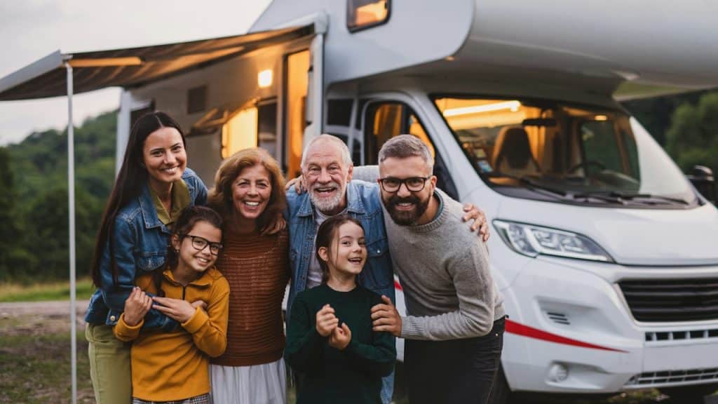 An older couple posing for a picture with their family in front of an RV.