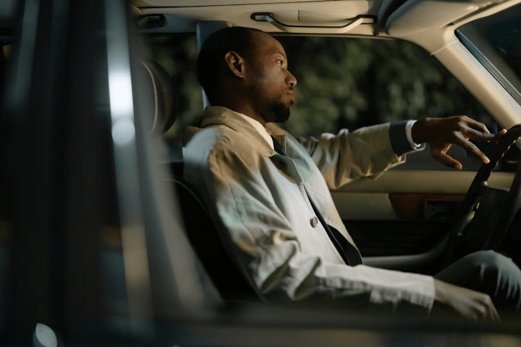 Man Wearing a Coat Sitting Inside a Car