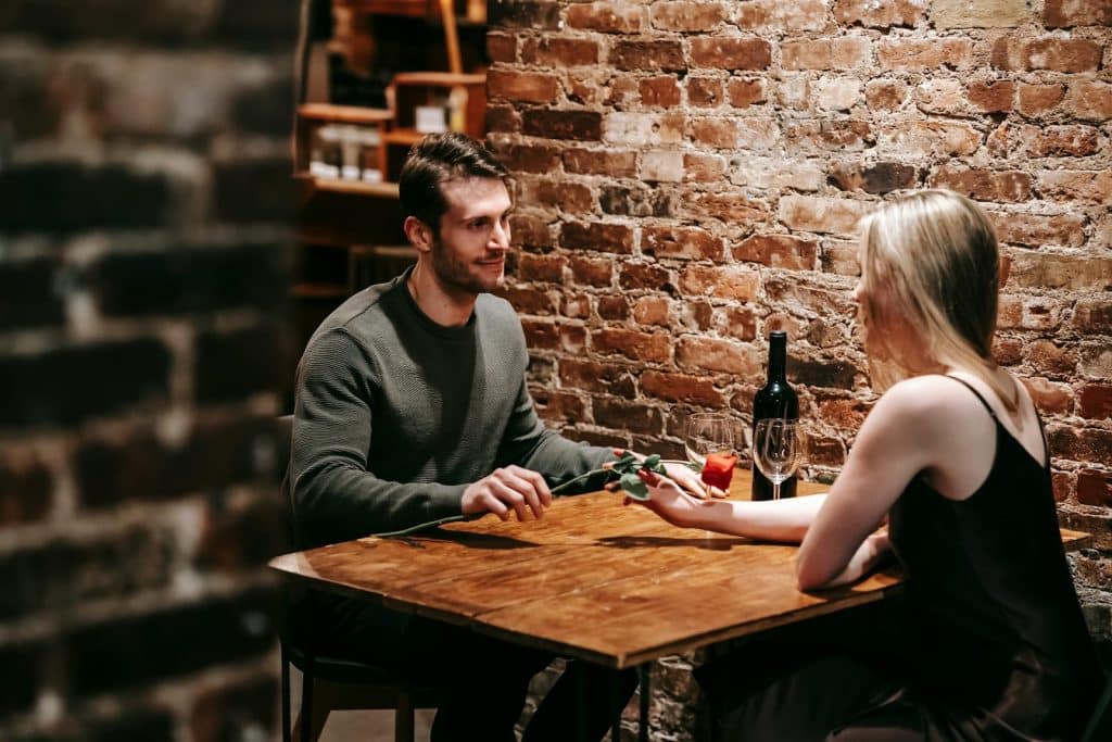 The couple is having a wine in a restaurant.