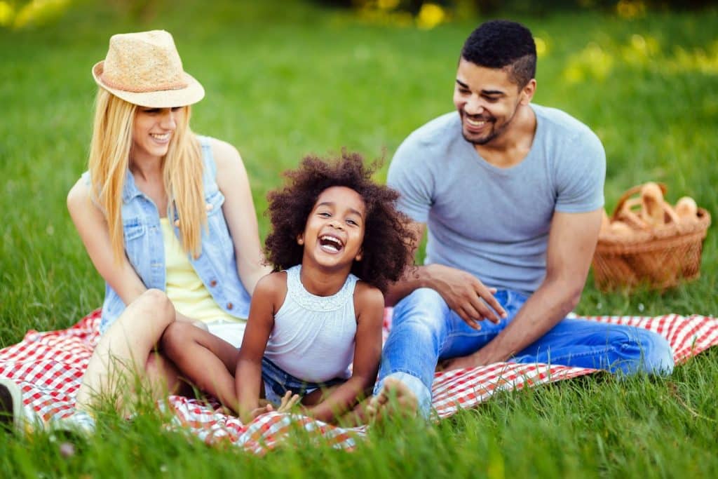 The young family is having a picnic in a park.