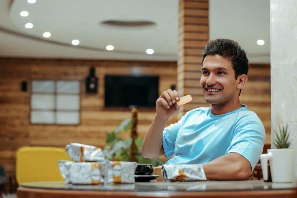 The man is looking at something across the room while smiling.