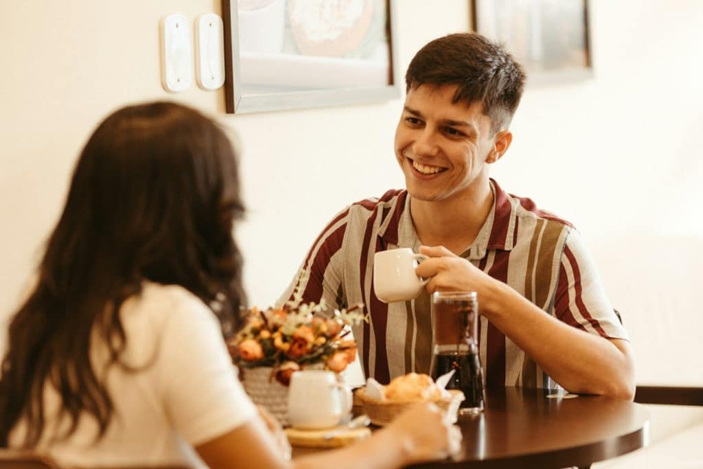 The man is sitting at a table with a woman.