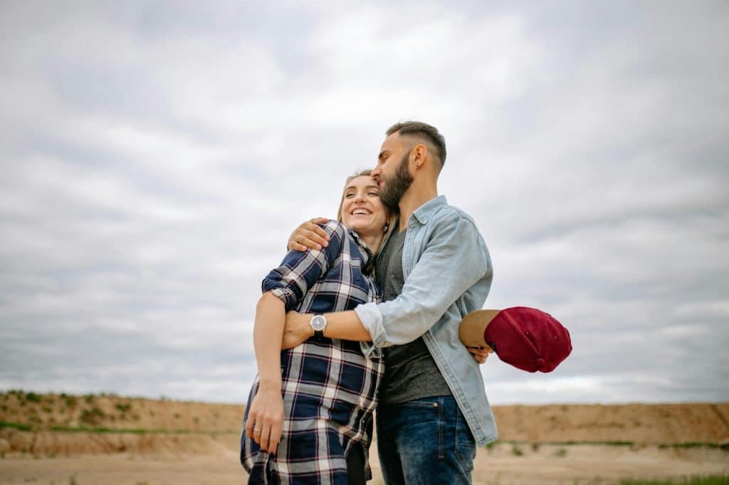 A man kissing woman’s head