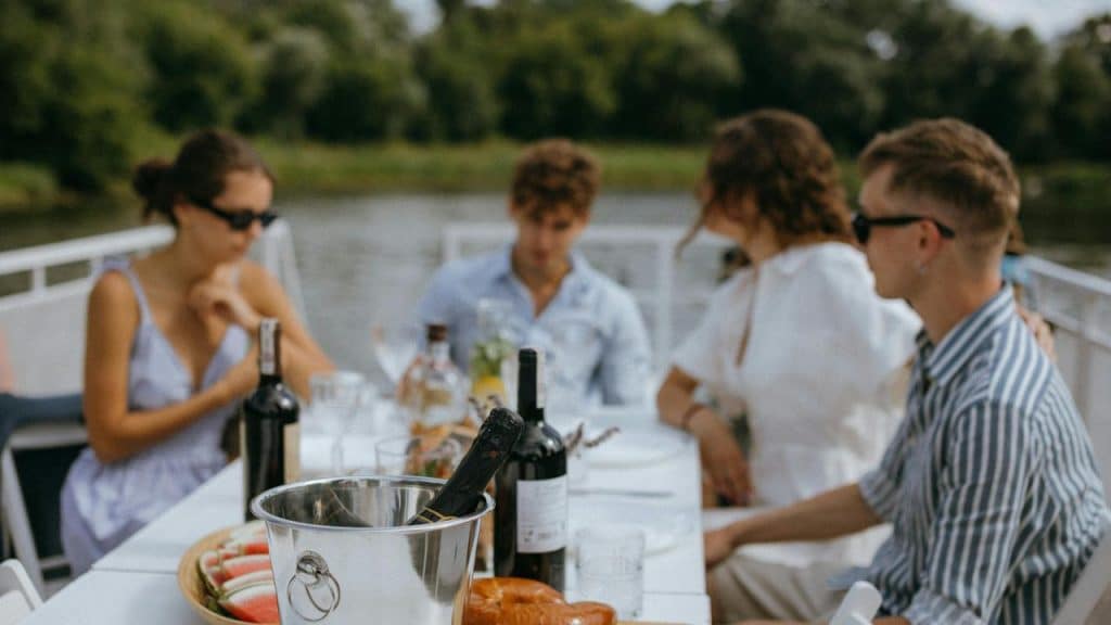 A group of friends having lunch on a boat by the water.