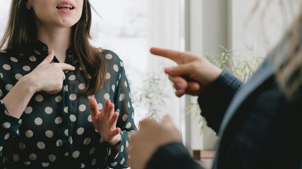 A woman using sign language while communicating with another person.