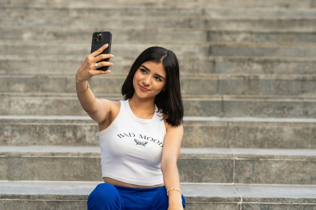 The woman is taking a selfie on her phone.