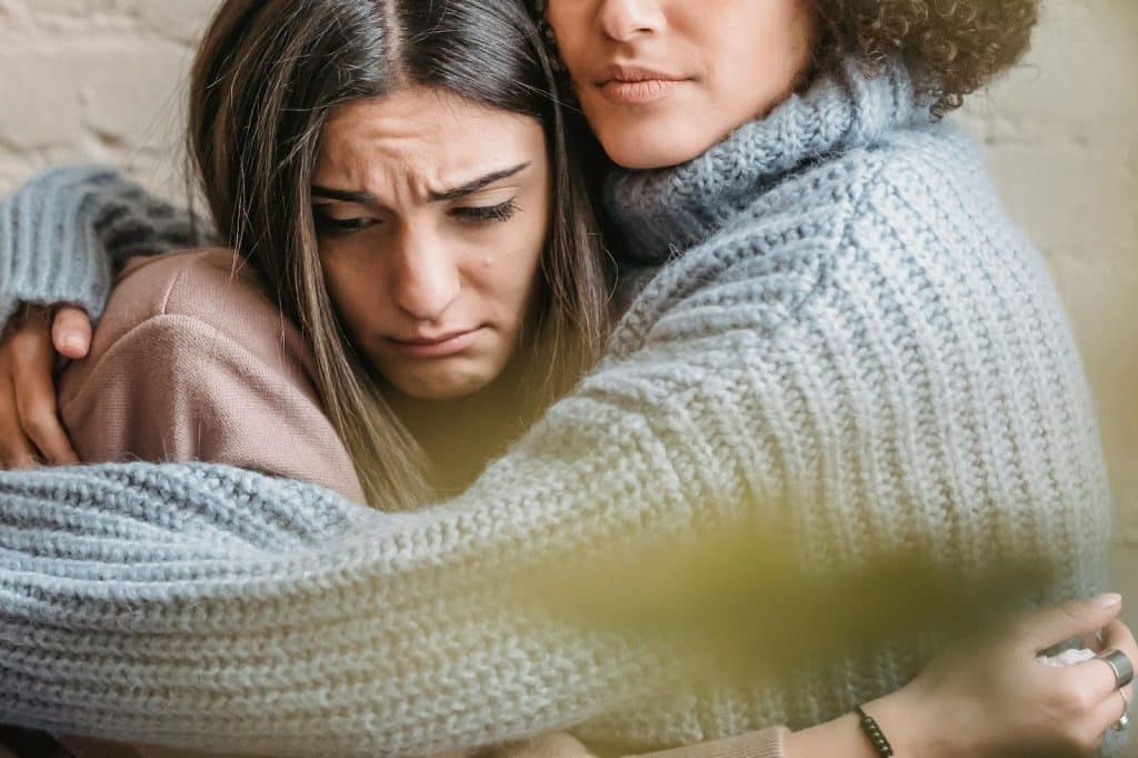 A woman seeking comfort from her friend