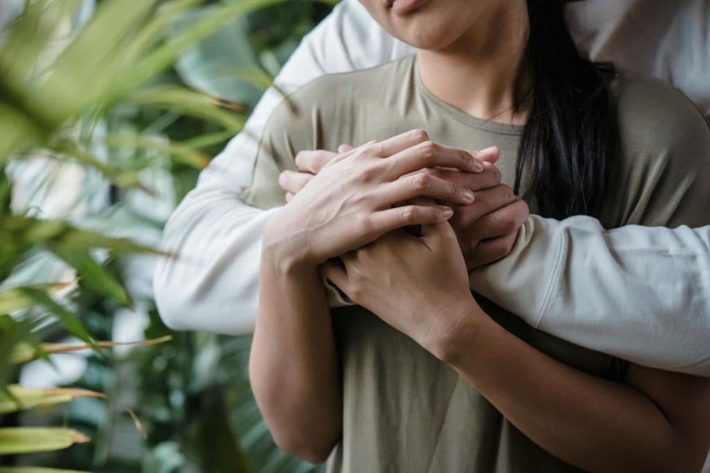 A man embracing a woman from behind