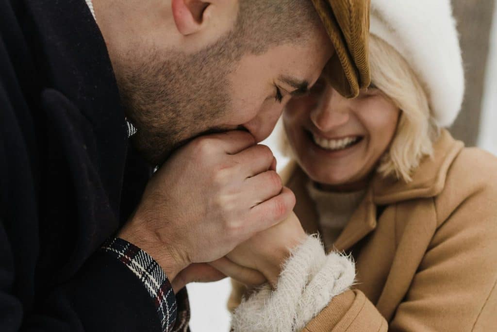 A man kissing a woman’s hands
