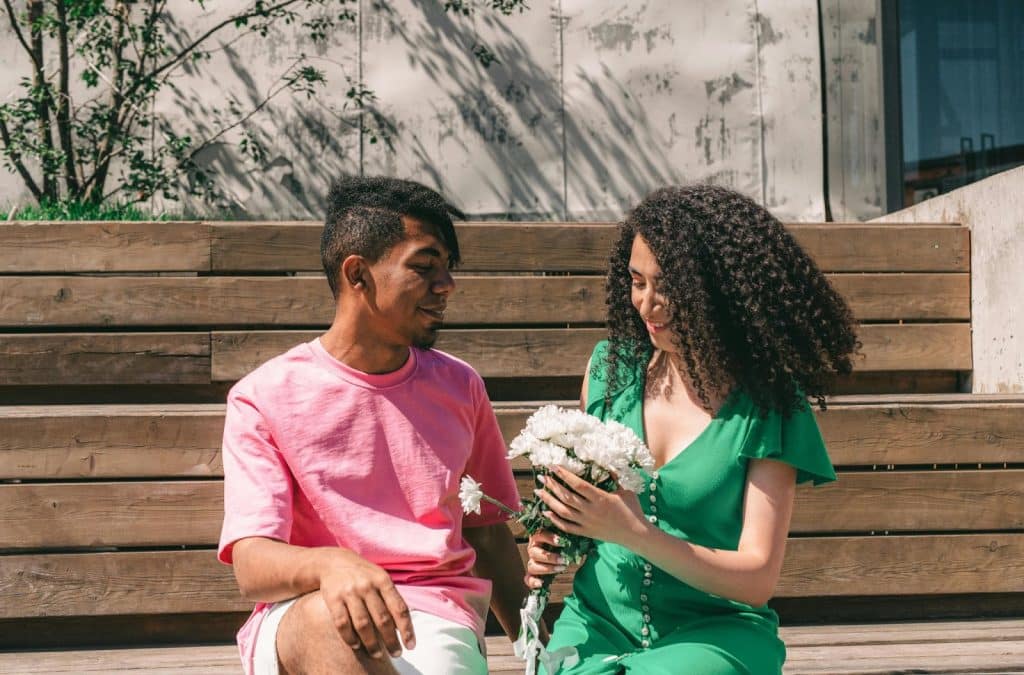 A man giving a flower to woman