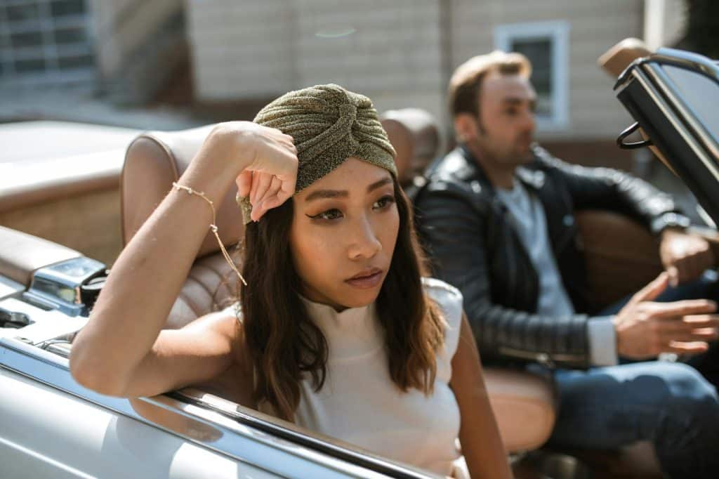 A man and woman at the car but not talking