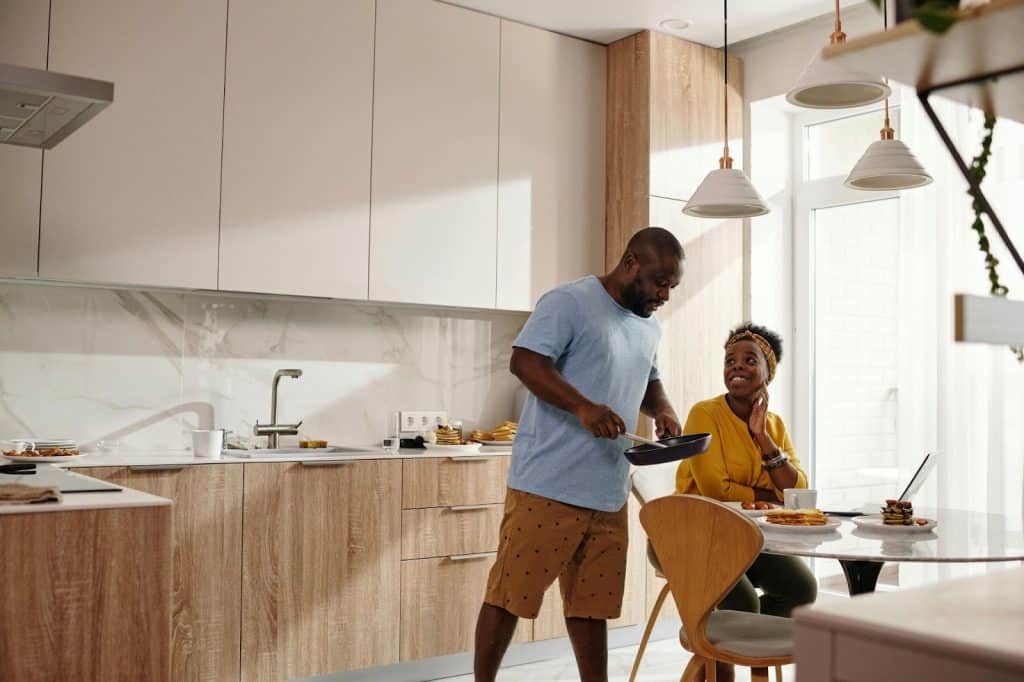 A man cooking a meal for a woman
