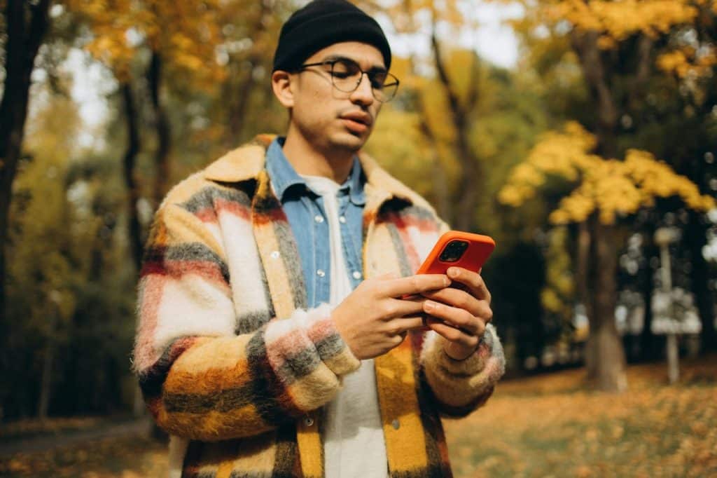 A man busy using a phone while outside