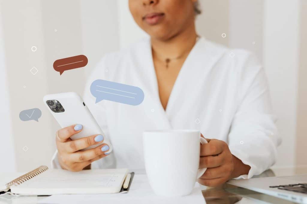 Woman holding a cup of coffee and a phone