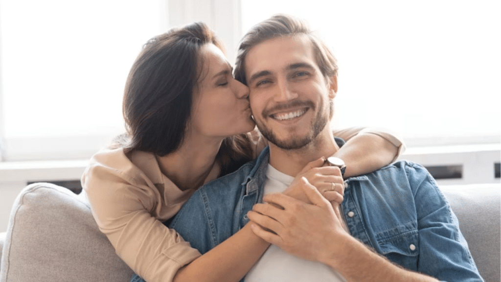 Smiling husband being complimented and kissed by his partner