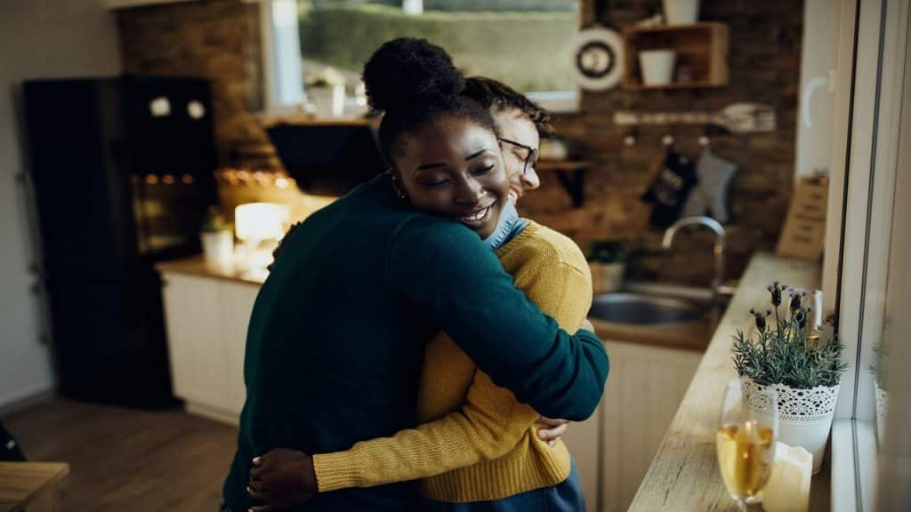 A couple hugging in the kitchen.
