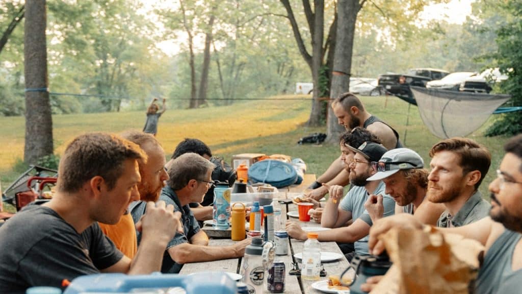 A group of people sitting around a picnic table.