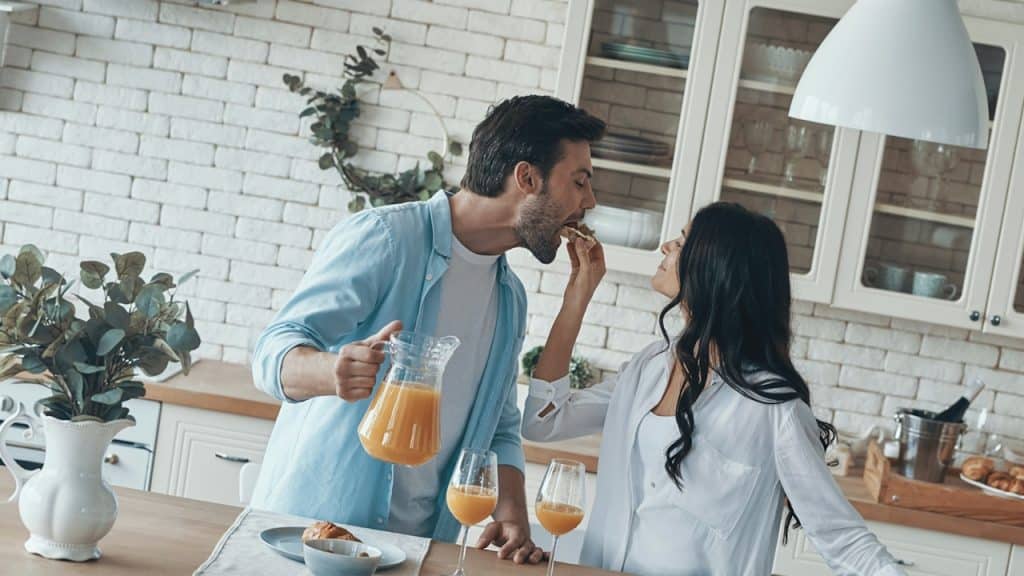 A happy young couple preparing breakfast together.