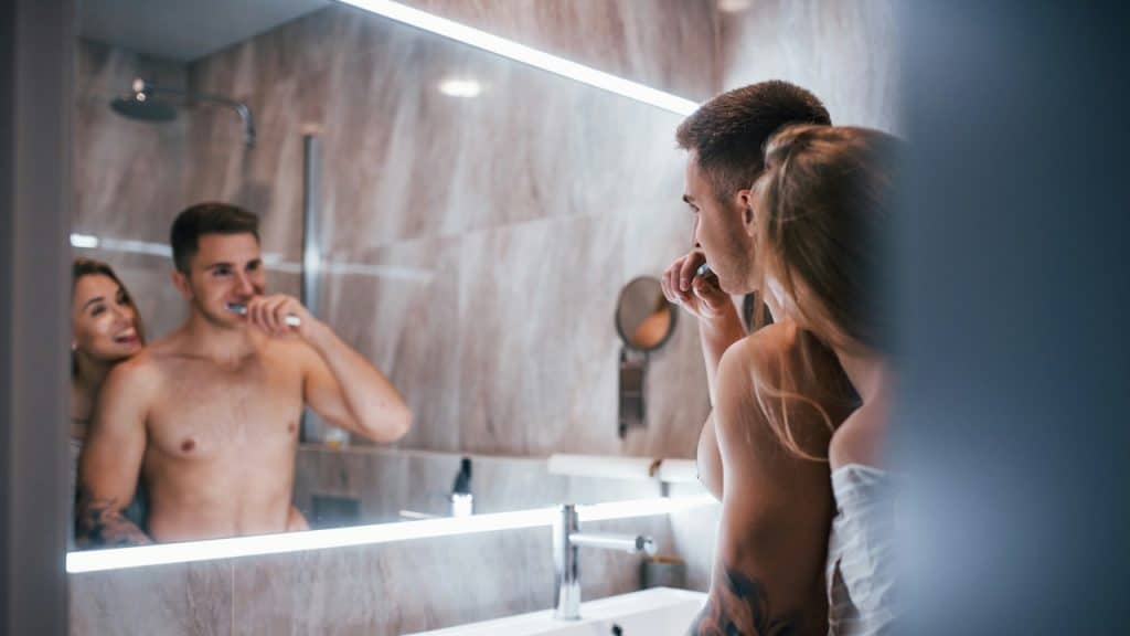 A young couple together in the bathroom.
