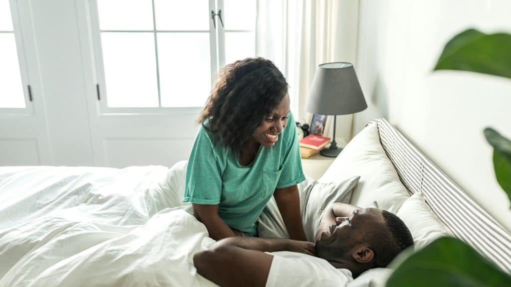 An african decent couple on the bed.