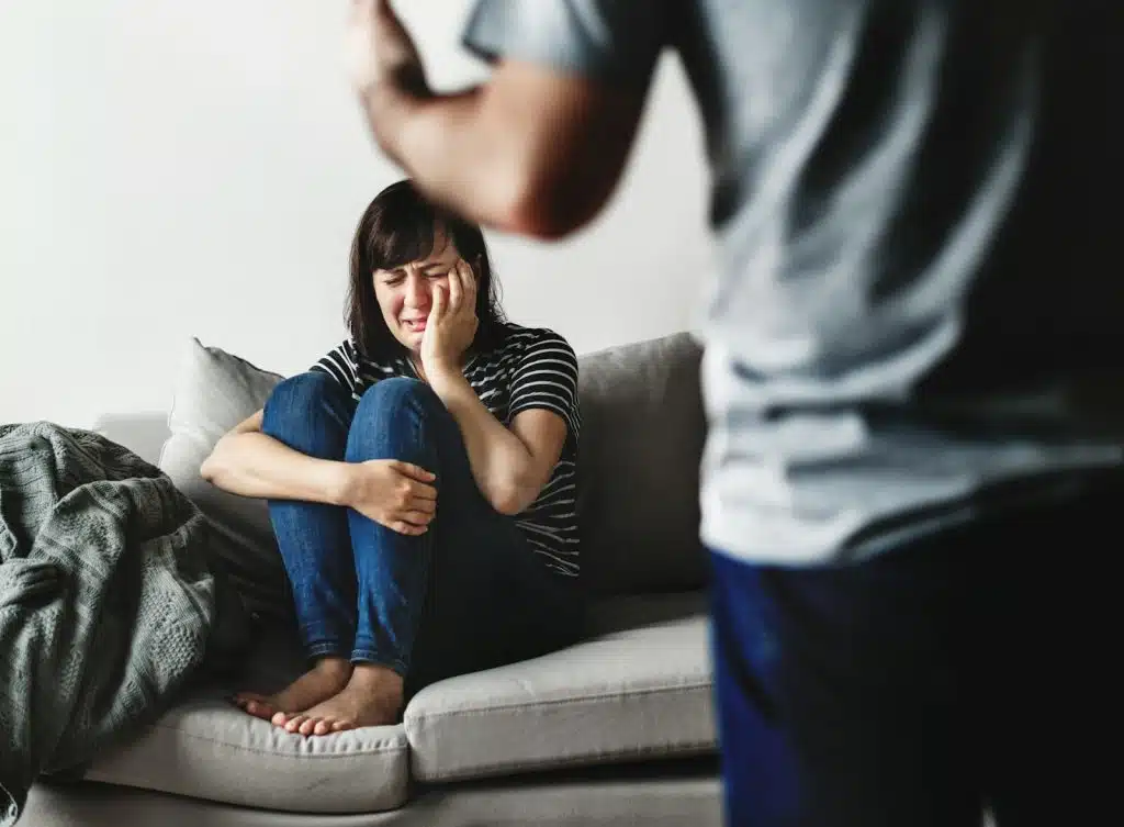 The woman is crying while having an argument with a man.