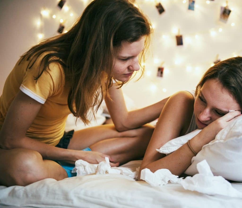 The woman in the yellow shirt is comforting her friend.