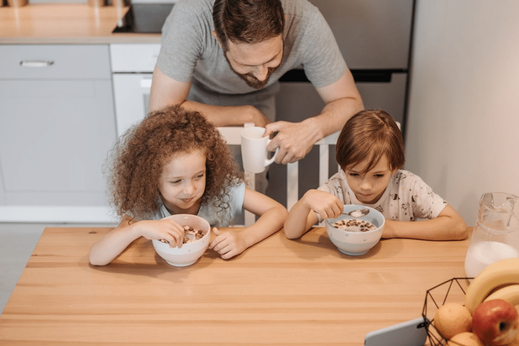 A Father Looking His Children While Eating
