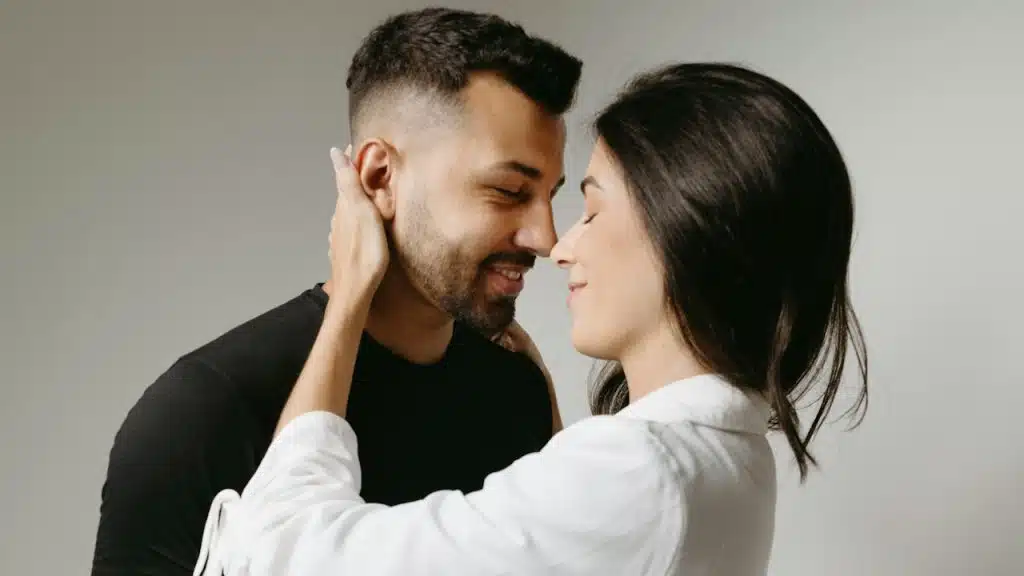 A couple about to kiss with their eyes closed in anticipation.