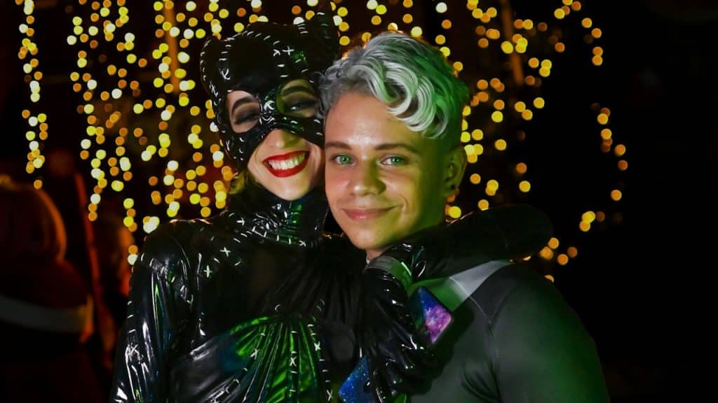 A couple wearing costumes and smiling at the camera.