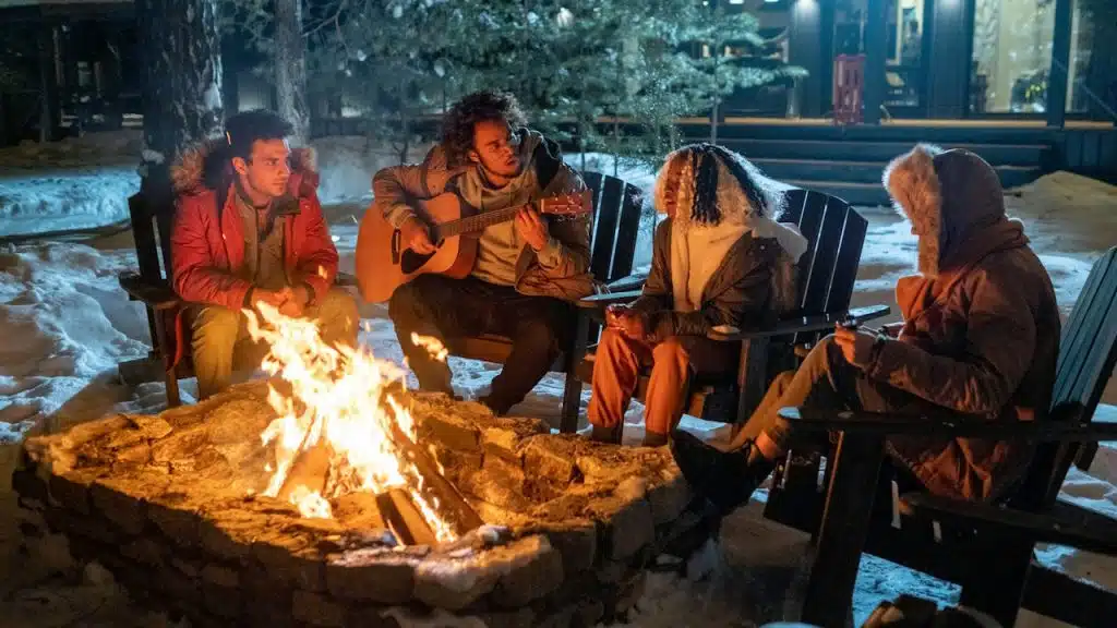 A group of friends sitting around a bonfire and having fun.