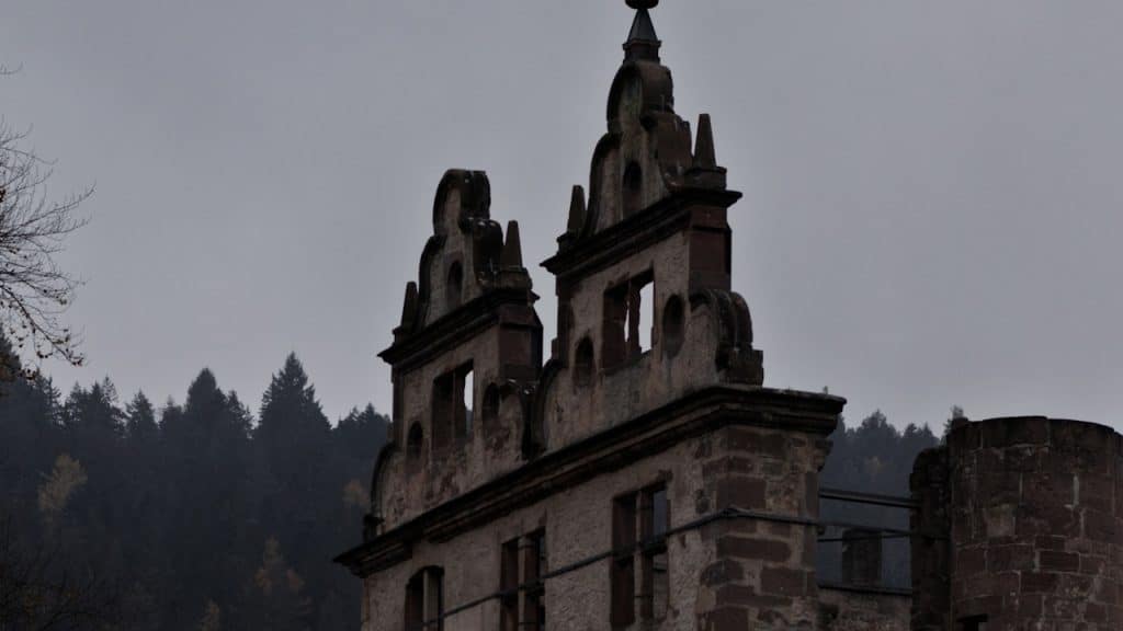 A view of a ruined church with woods in the background.