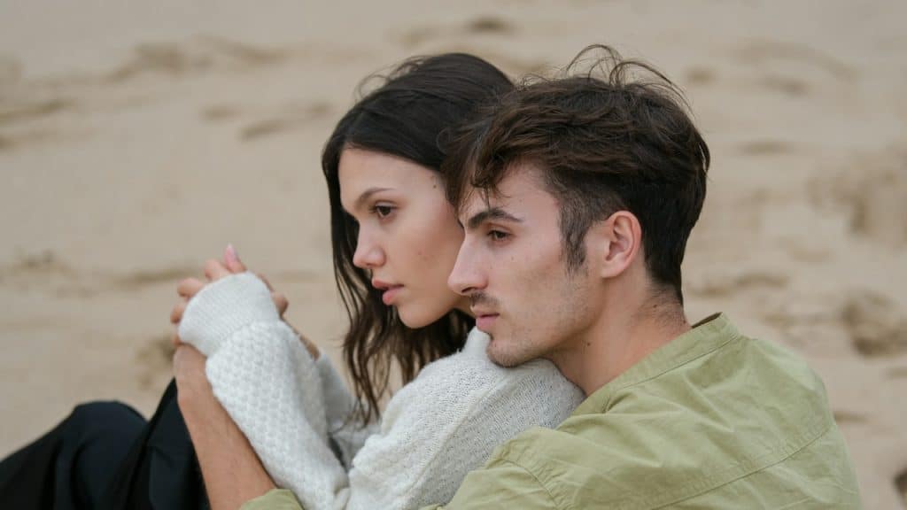 A man holding a woman from behind while sitting.