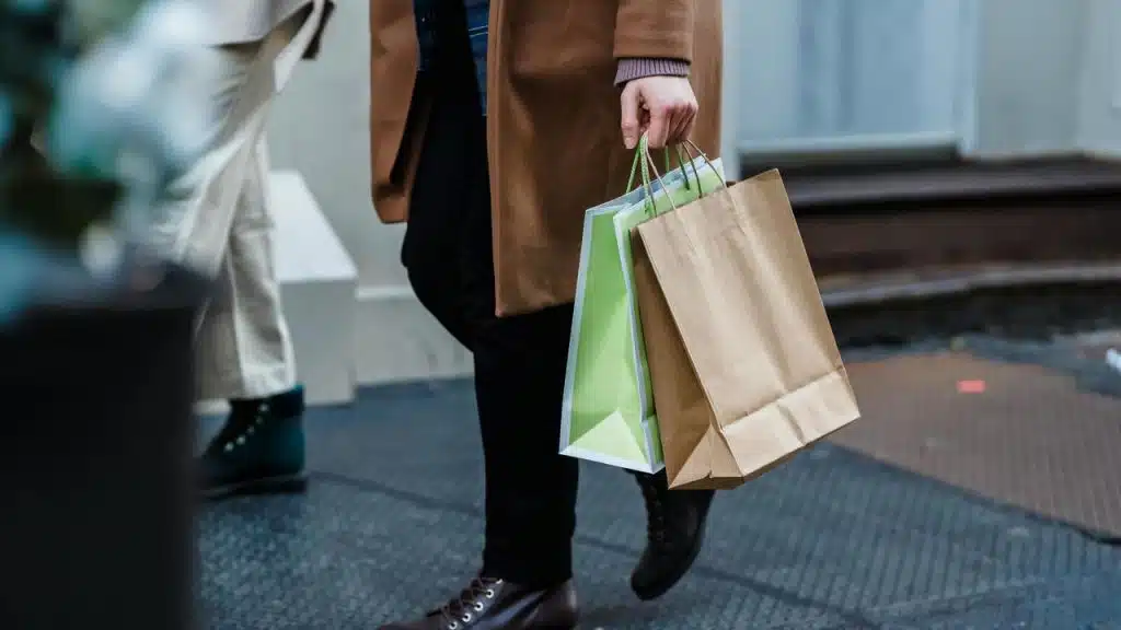 A person walking outside carrying shopping bags.