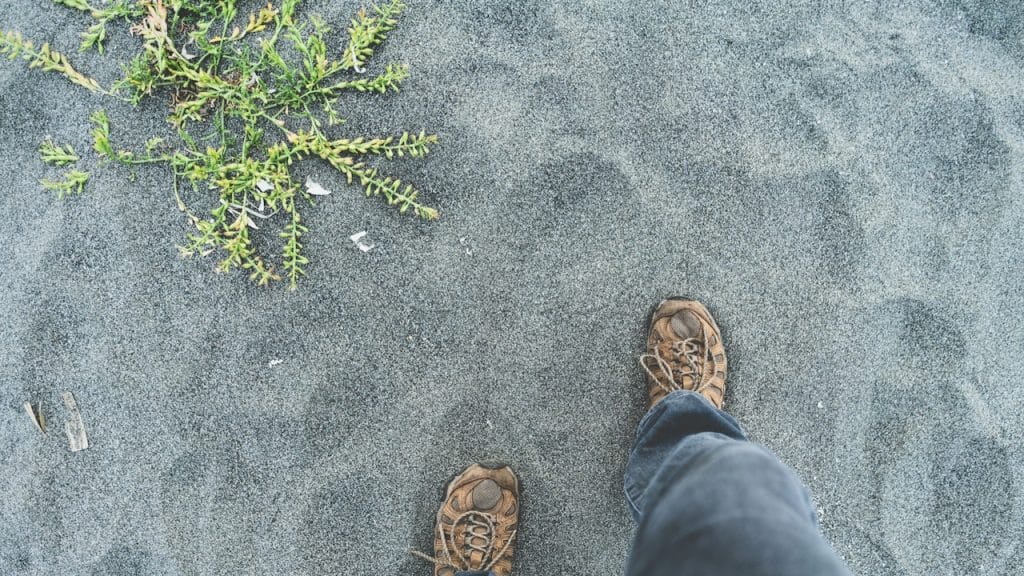Person standing on gray sand
