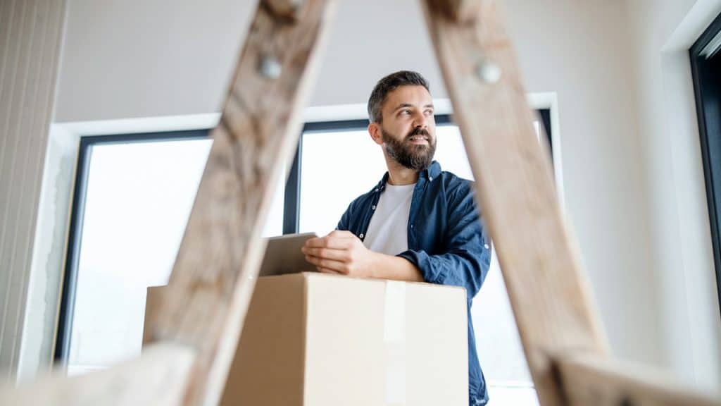 A bearded man working on something and looking to the side.