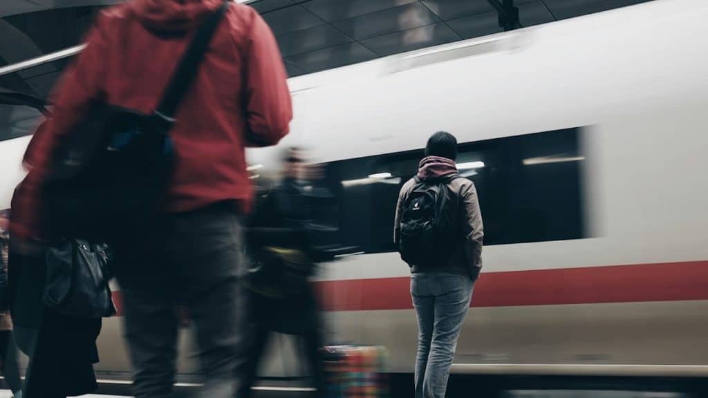 Man standing near a moving train.