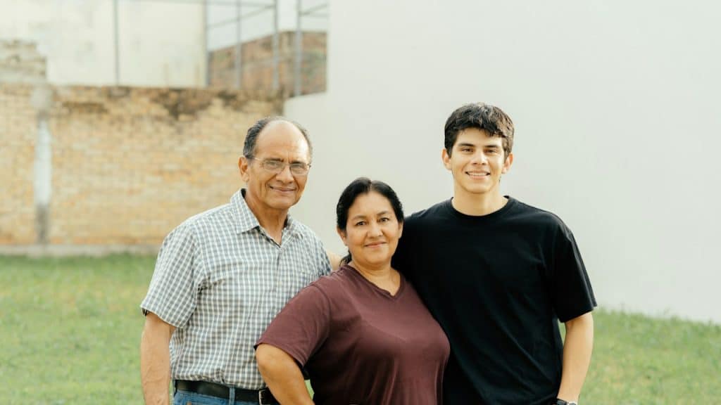A man posing for a photo with his parents.