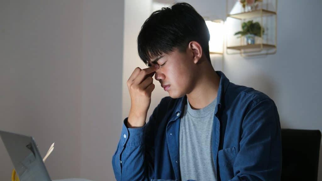 Young man working overtime and feeling tired.
