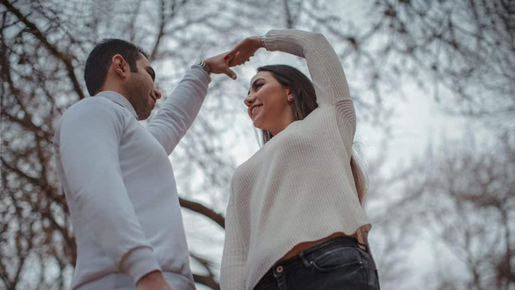 Portrait of a couple dancing under a tree.