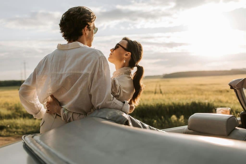 A man and woman leaning to a car