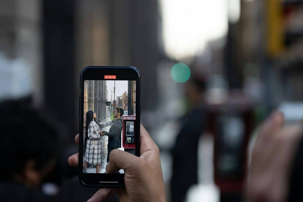 A person taking a picture of a couple